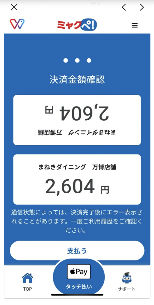 Mobile payment screen showing a 2,604円 amount for まれきダイニング万博店舗, with a large white rounded “支払う” button and an Apple Pay “タッチ払い” option at the bottom, plus bottom navigation icons for TOP and Support.